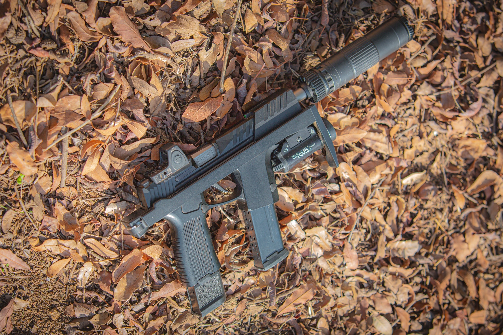 SIG 365 Reaper chassis with suppressor lying in the leaves
